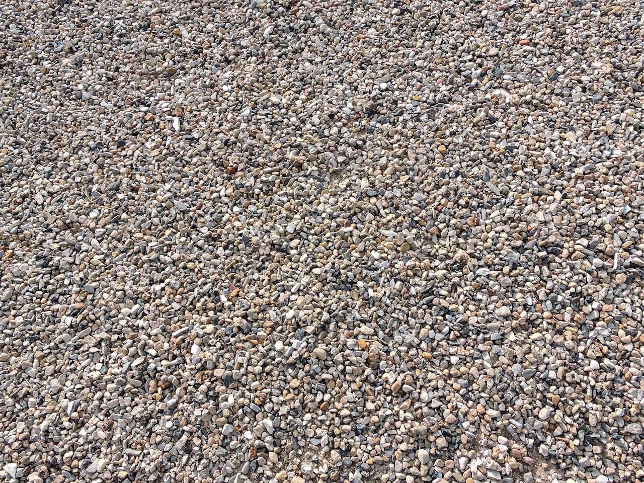 Services-01 Detailed texture of small gravel stones in a dry setting.